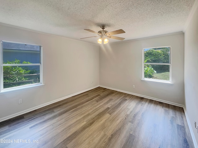 spare room featuring ceiling fan, wood-type flooring, and a textured ceiling