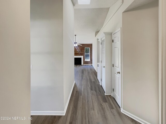 hall with vaulted ceiling and wood-type flooring