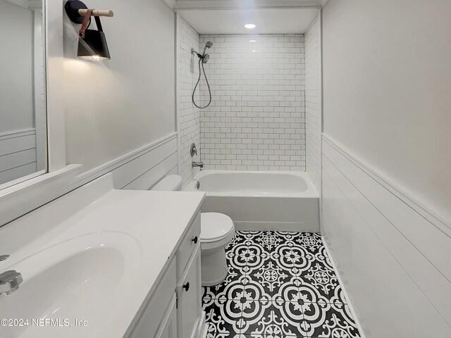 full bathroom with tile patterned flooring, toilet, tiled shower / bath combo, and vanity