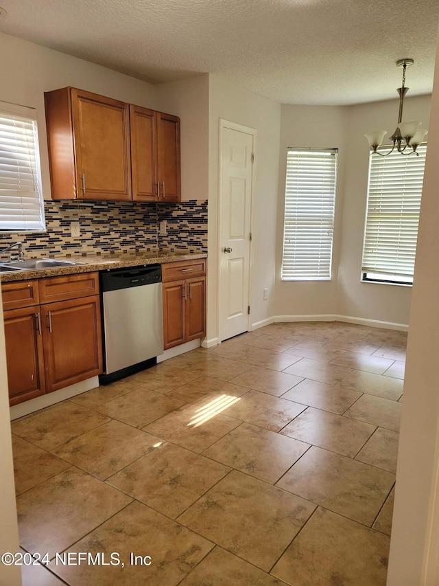 kitchen with backsplash, sink, a chandelier, dishwasher, and light tile patterned floors