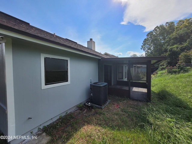 rear view of property with a yard and central AC