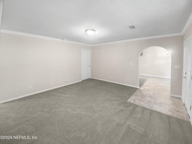 empty room with baseboards, arched walkways, ornamental molding, dark colored carpet, and a textured ceiling