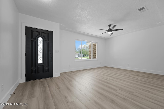 foyer featuring a textured ceiling, ceiling fan, and light hardwood / wood-style flooring