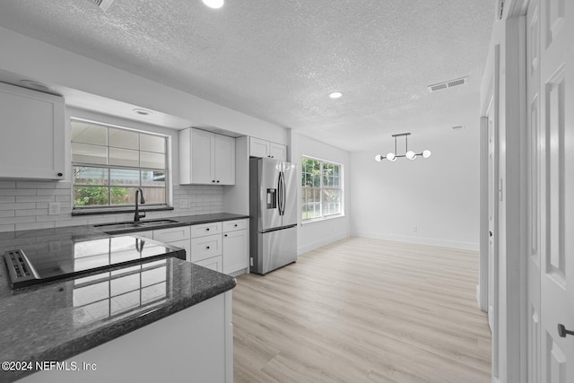 kitchen with plenty of natural light, sink, tasteful backsplash, and stainless steel fridge with ice dispenser