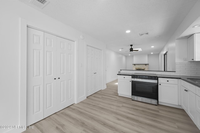 kitchen featuring light wood-type flooring, kitchen peninsula, and white cabinets