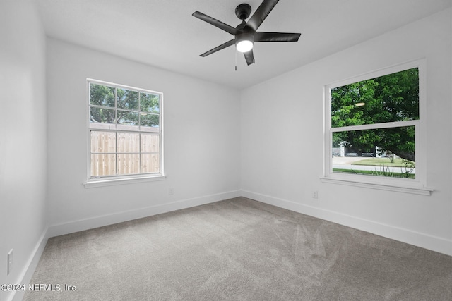 carpeted spare room featuring ceiling fan