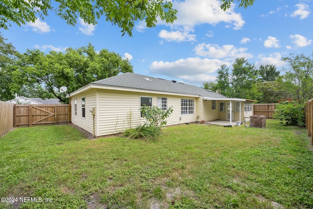 rear view of property with a patio and a yard