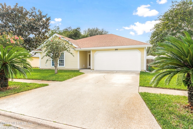 single story home featuring a garage and a front lawn