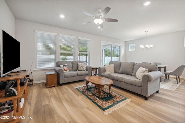 living area featuring light wood-style floors, recessed lighting, baseboards, and ceiling fan with notable chandelier