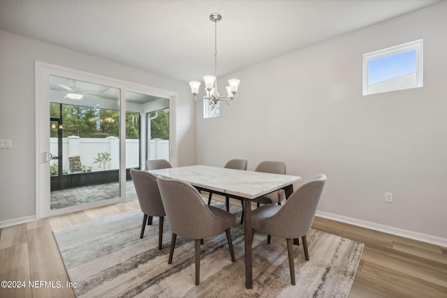 dining room with a notable chandelier, light wood finished floors, and baseboards