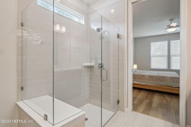 ensuite bathroom featuring plenty of natural light, ceiling fan, connected bathroom, and a shower stall