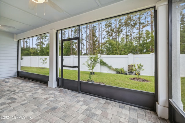 unfurnished sunroom with plenty of natural light and ceiling fan