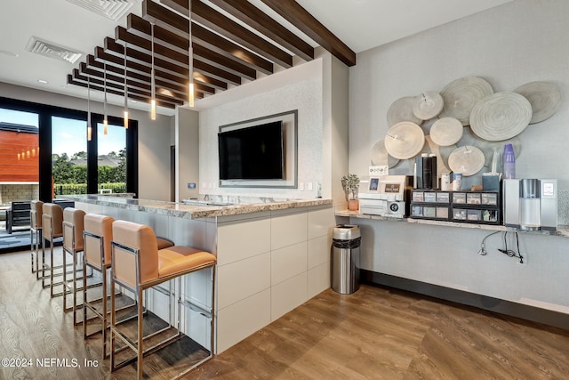 kitchen with visible vents, wood finished floors, and beam ceiling