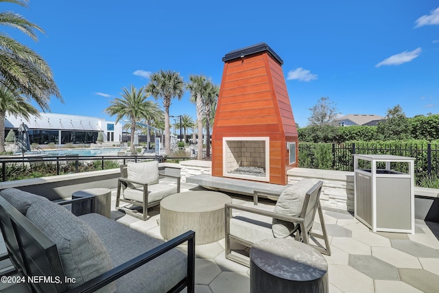 view of patio / terrace featuring fence and an outdoor living space with a fireplace