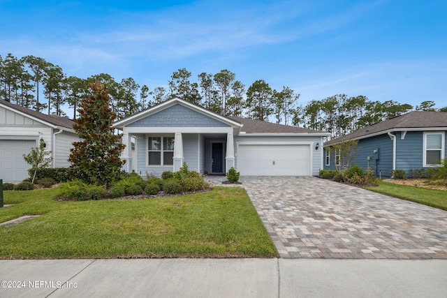 view of front of home featuring a front lawn, decorative driveway, and an attached garage