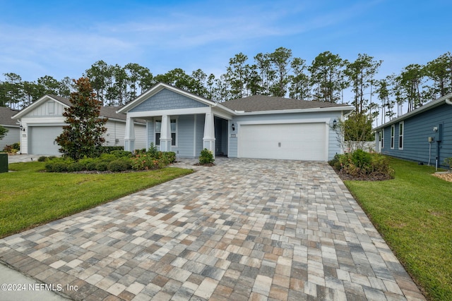 view of front of home with an attached garage, decorative driveway, and a front yard