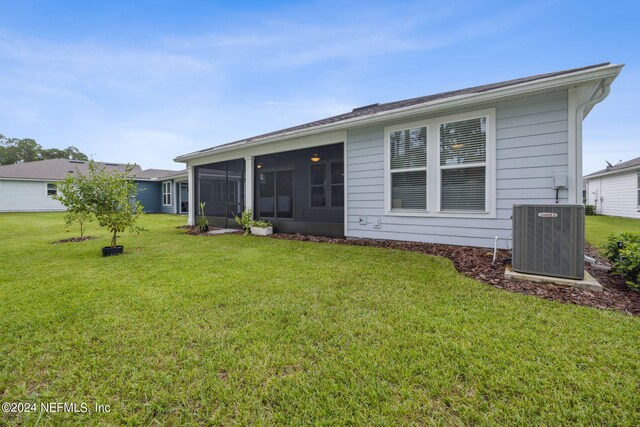 back of house featuring a sunroom, cooling unit, and a yard