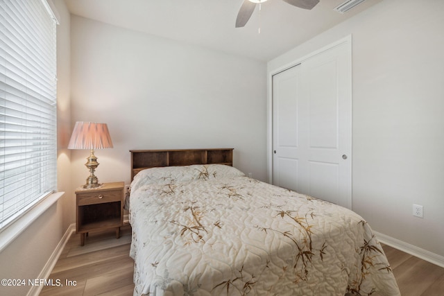 bedroom with ceiling fan, a closet, baseboards, and wood finished floors