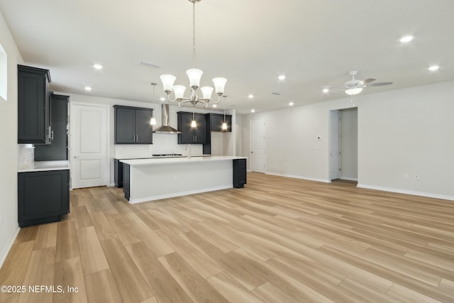 kitchen with decorative backsplash, open floor plan, light countertops, and wall chimney exhaust hood