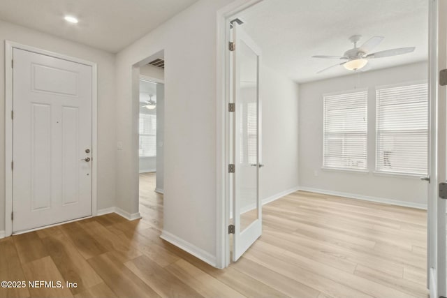 entryway featuring light wood-type flooring, ceiling fan, and baseboards