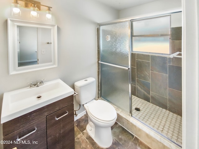 bathroom with tile patterned flooring, a shower with door, toilet, and vanity