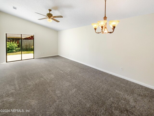 empty room featuring ceiling fan with notable chandelier, vaulted ceiling, and carpet flooring