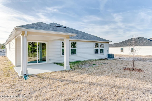 rear view of house featuring a lawn, central AC unit, and a patio area