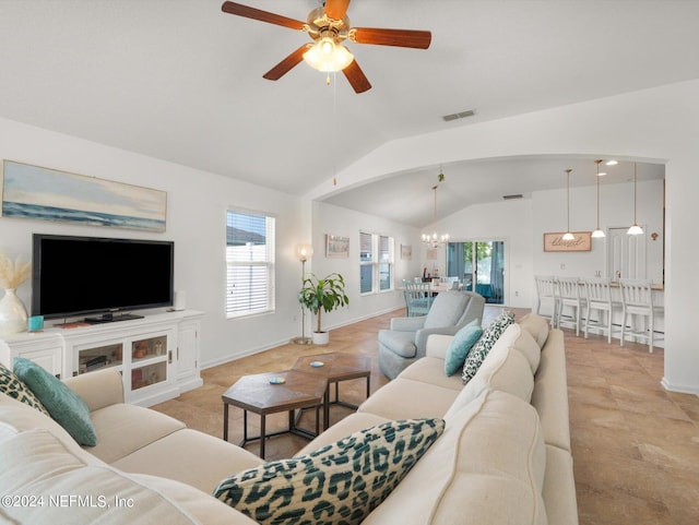 living room with vaulted ceiling, ceiling fan with notable chandelier, and light tile patterned flooring