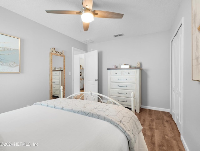 bedroom featuring ceiling fan, a closet, and hardwood / wood-style floors