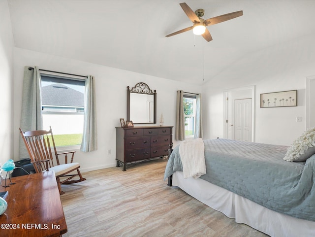 bedroom with ceiling fan, vaulted ceiling, and light hardwood / wood-style floors