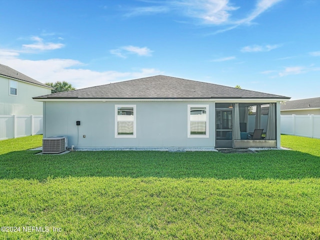 rear view of house with a sunroom, cooling unit, and a yard