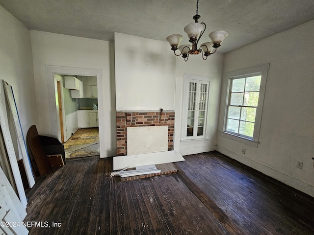 unfurnished living room featuring a chandelier and hardwood / wood-style flooring