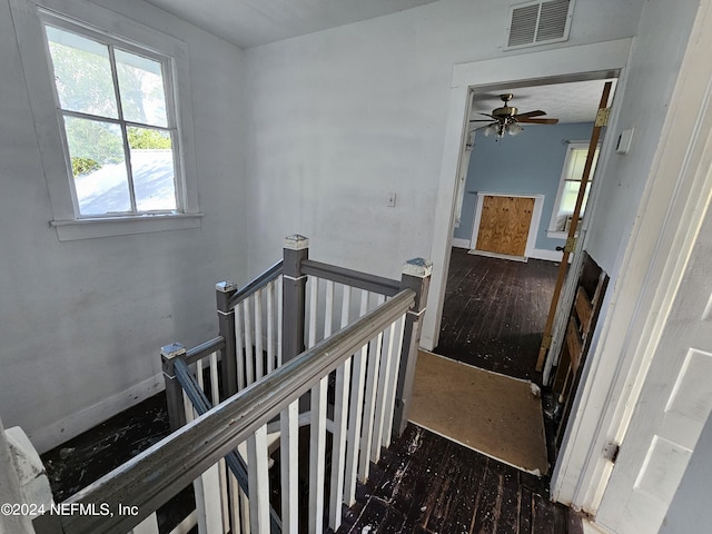 stairway featuring hardwood / wood-style flooring, visible vents, and baseboards