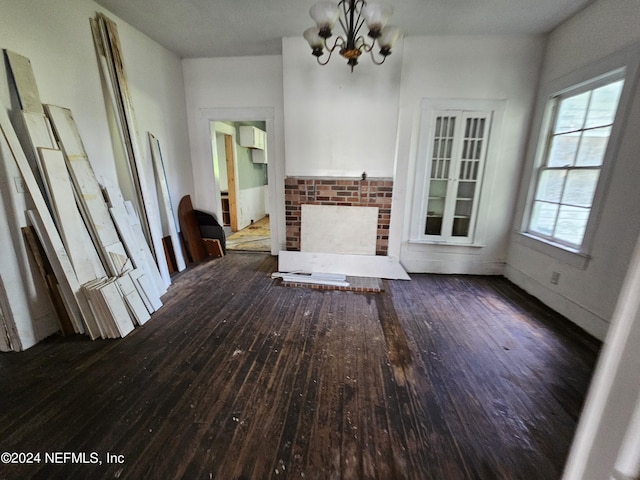 unfurnished living room featuring a notable chandelier, a fireplace, and hardwood / wood-style floors
