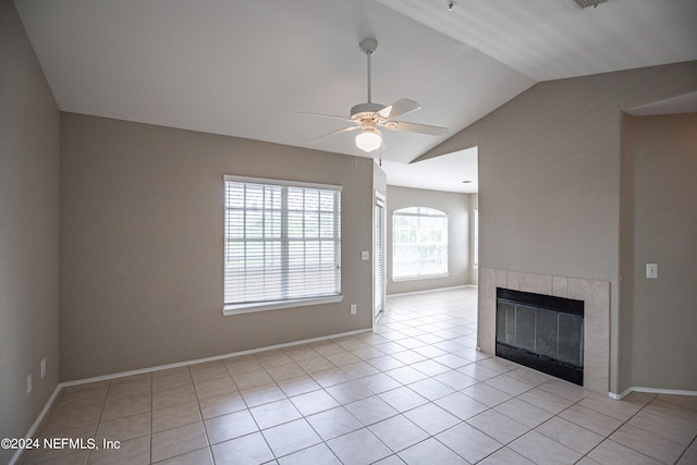 unfurnished living room featuring light tile patterned floors, a tiled fireplace, a ceiling fan, vaulted ceiling, and baseboards