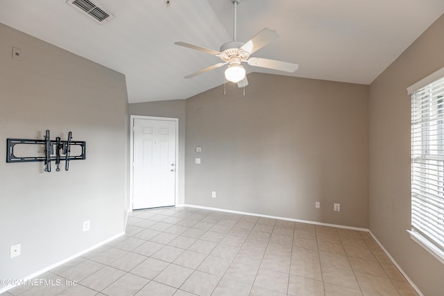 unfurnished room featuring light tile patterned floors, visible vents, baseboards, vaulted ceiling, and a ceiling fan