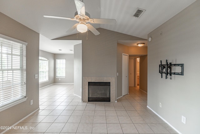 unfurnished living room with baseboards, visible vents, a tile fireplace, vaulted ceiling, and light tile patterned flooring