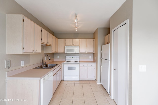 kitchen with light tile patterned floors, white appliances, a sink, light countertops, and track lighting