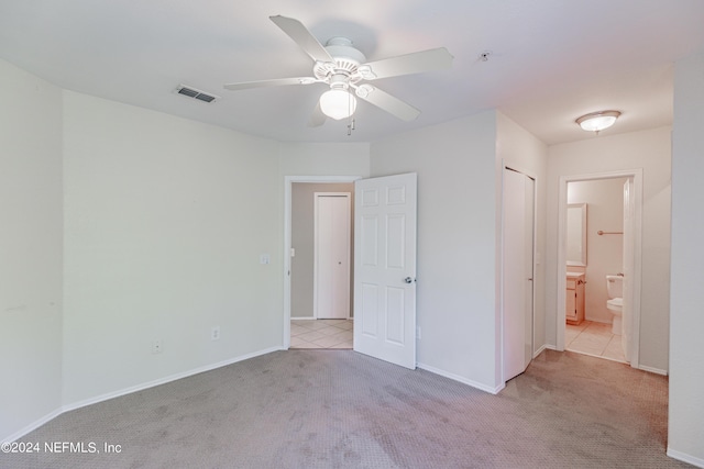 unfurnished bedroom featuring baseboards, visible vents, carpet flooring, and ensuite bathroom