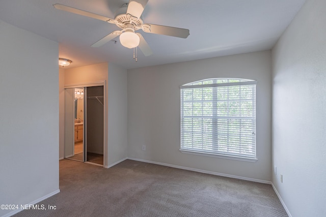 unfurnished room with carpet floors, a ceiling fan, and baseboards