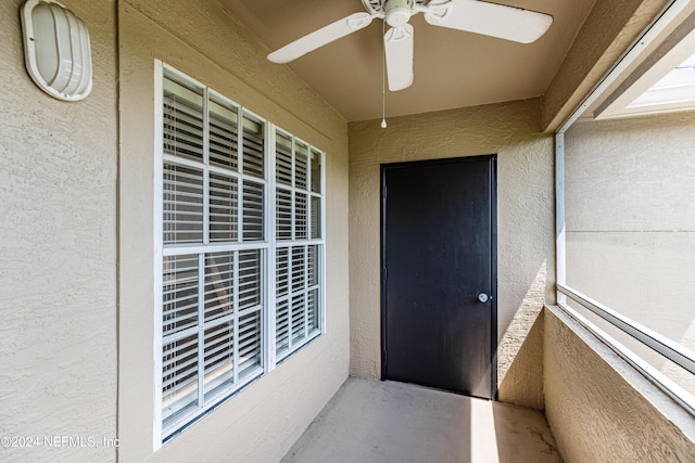 unfurnished sunroom featuring ceiling fan