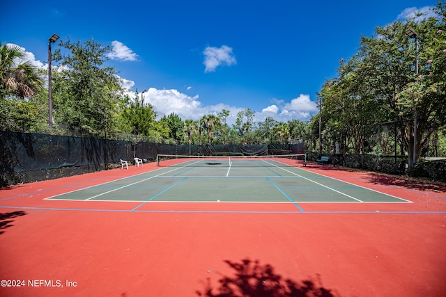 view of tennis court with community basketball court and fence