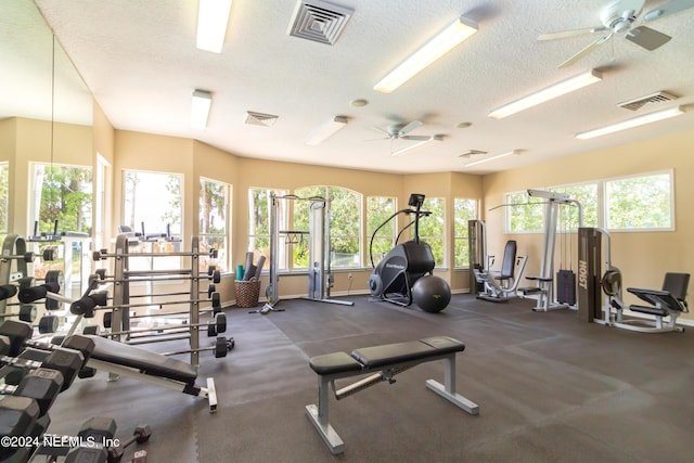 exercise room featuring baseboards, visible vents, and a textured ceiling