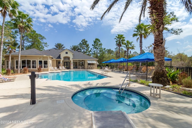 community pool with fence, a community hot tub, and a patio