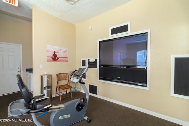 workout area with a textured ceiling and baseboards