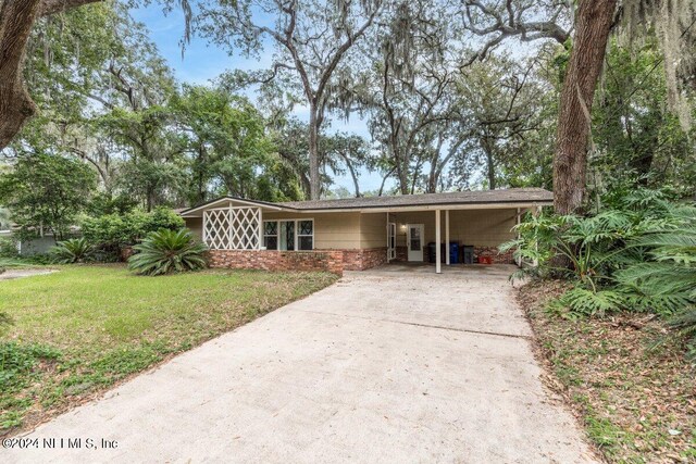 single story home featuring a front lawn and a carport