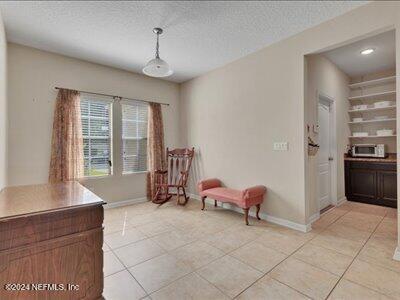 living area with a textured ceiling and light tile patterned floors