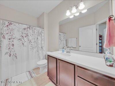 bathroom with toilet, tile patterned floors, and vanity