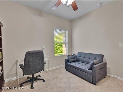 carpeted home office featuring ceiling fan