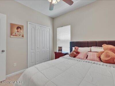 carpeted bedroom featuring a closet and ceiling fan